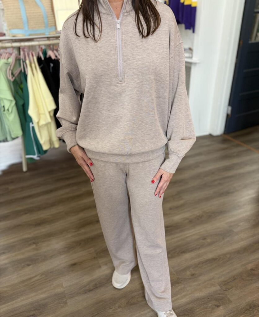 Person wearing a matching beige quarter-zip sweatshirt and wide-leg sweatpants lounge set.