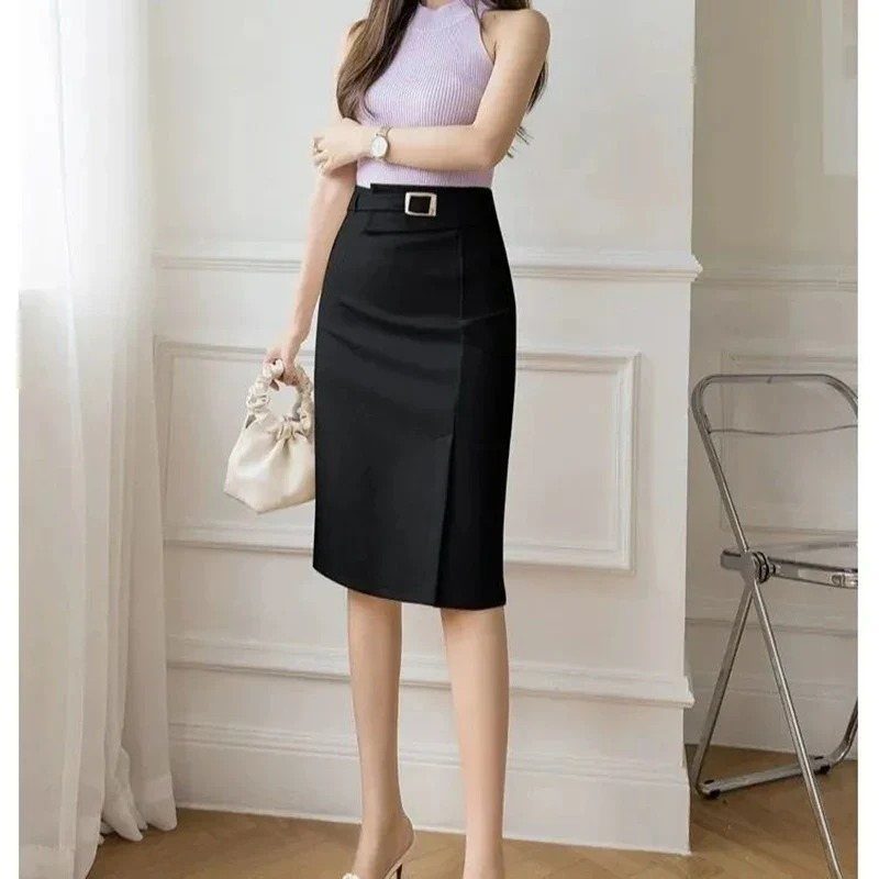 A woman wearing a purple knit top and a black high-waisted pencil skirt.